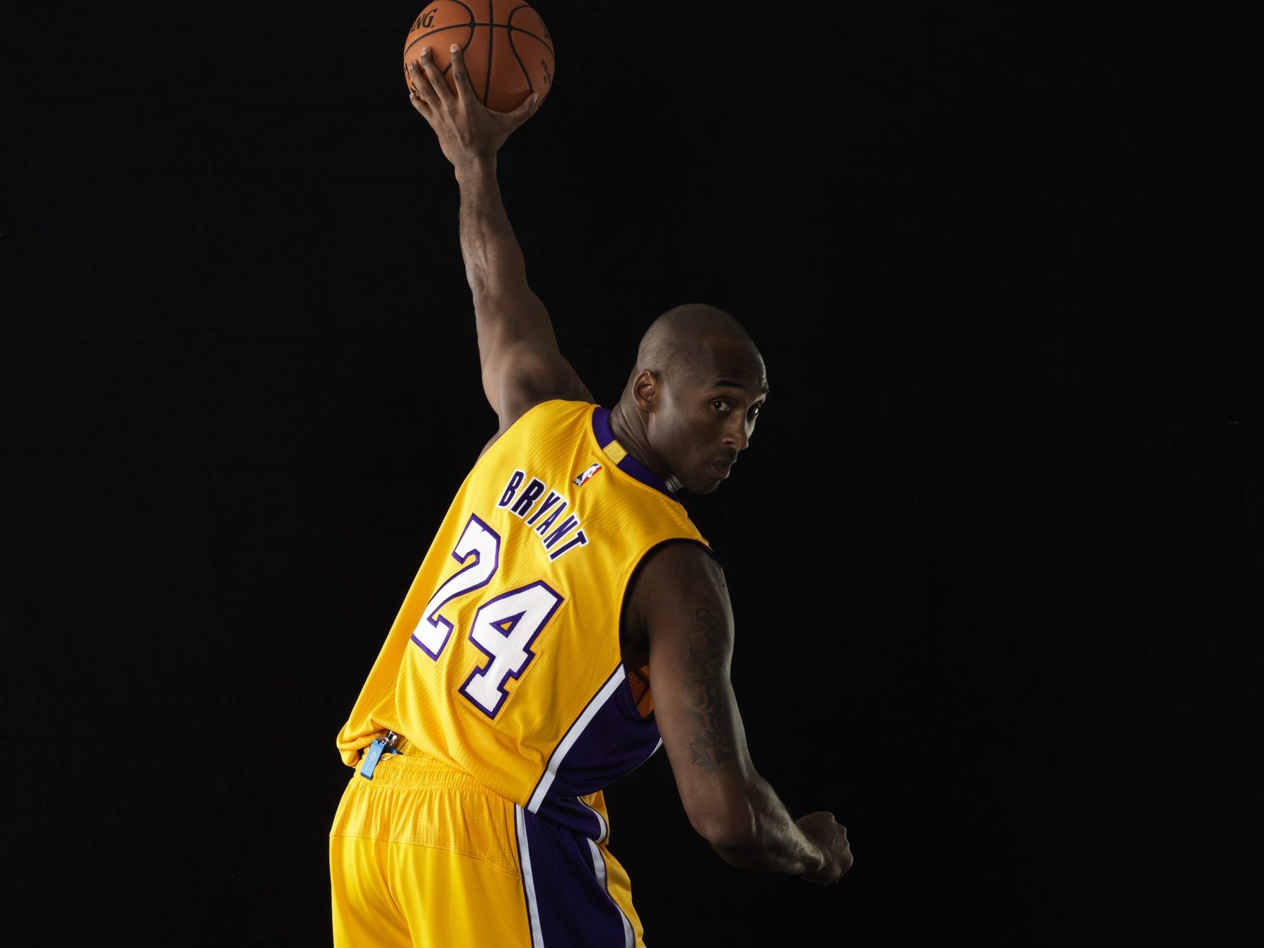 Studio portrait of Kobe Bryant in a number 24 Lakers jersey on black